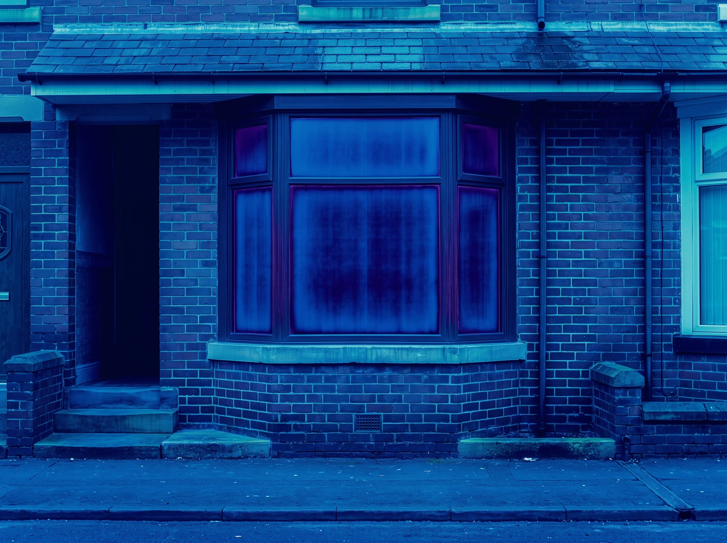 A photograph of a brick house facade with a bay window and open doorway, tinted entirely in blue.